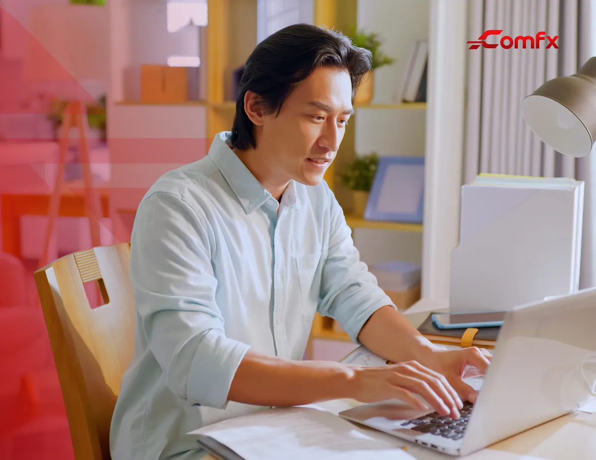 Remote team member typing on a laptop at a home desk